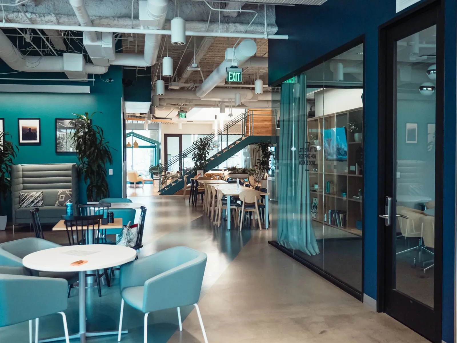 Open and collaborative modern office space with stylish furniture and natural lighting.
